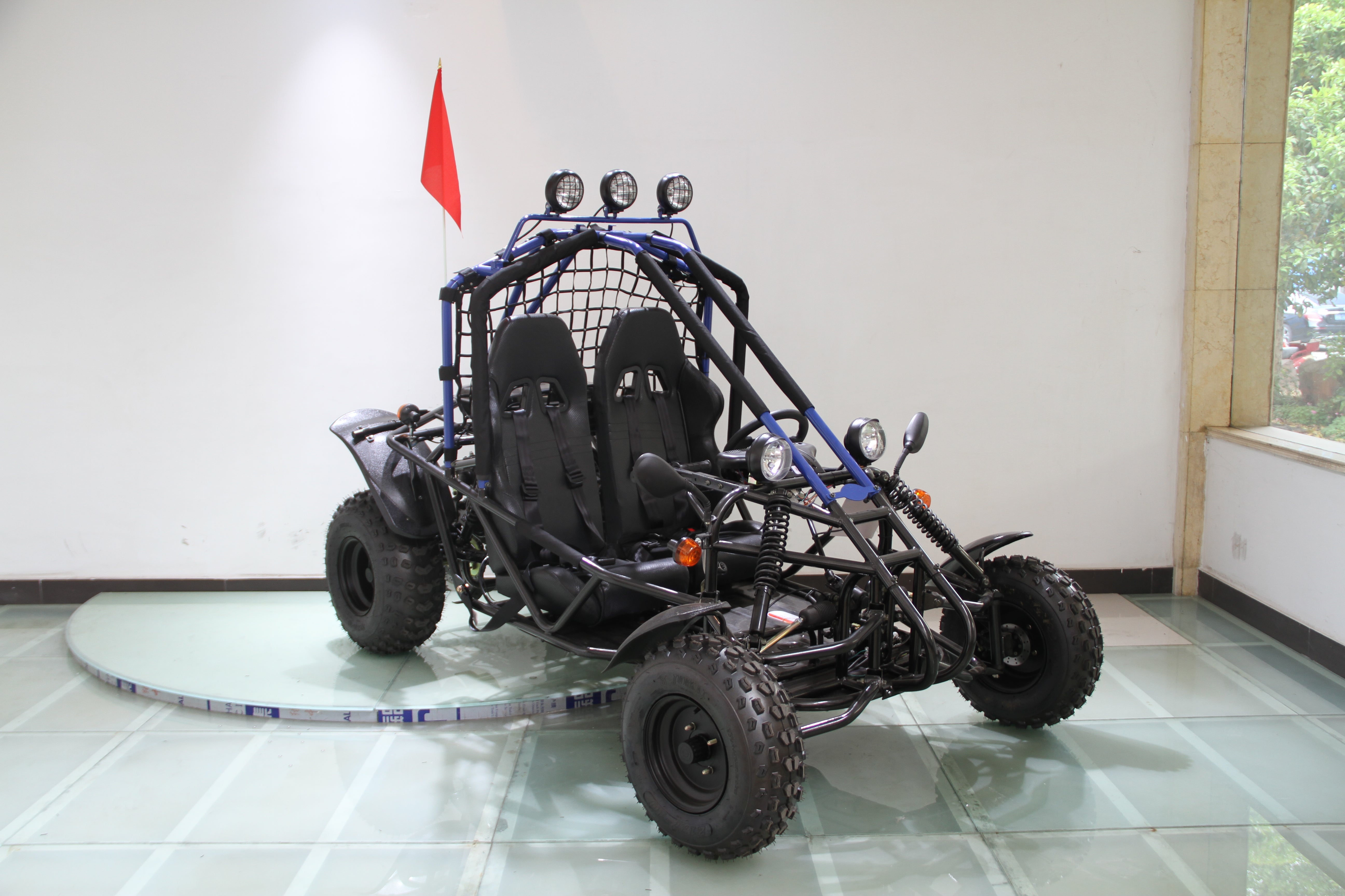 Off-road go-kart with black frame and blue accents from a different angle